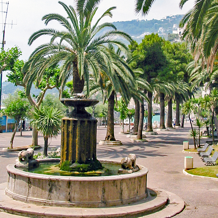 Promenade von Minori mit Löwenbrunnen Promenade von Minori mit Löwenbrunnen unter Palmen